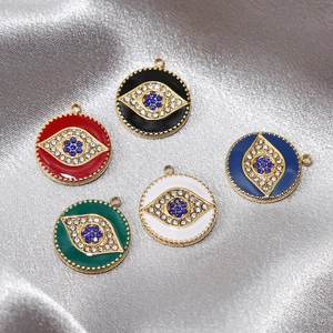 Goldene Evil Eye Anhänger mit bunter Emaille und Kristallen auf glänzendem Satinstoff