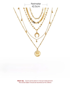 Detail of gold layered chain necklace featuring crescent moon and coin portrait pendants