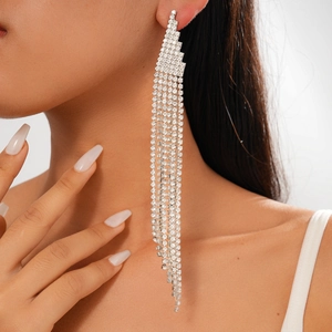 Close-up of sparkling long tassel earrings with silver rhinestones on a female model