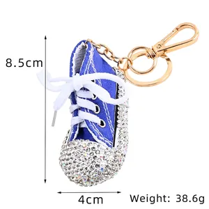 Kreativer blauer Turnschuh-Schlüsselanhänger mit bunten Strasssteinen und Goldclip