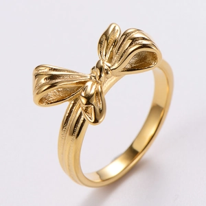 Macro shot of polished gold bow ring showing the reflective mirror finish and fine casting detail