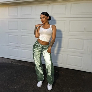 Detail view of green and white textured wide-leg trousers on model in street setting