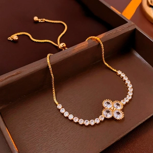 Detailed macro view of adjustable gold clover bracelet with sparkling zircon stones