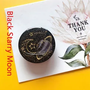 Close-up of black planet phone socket with gold glitter moon and stars on card