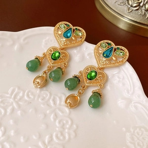 Dettaglio orecchini vintage stile corte con pietre preziose verdi e blu lucide