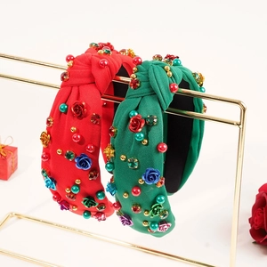 Detail of red and green knotted fabric headbands with floral embroidery and colorful beads