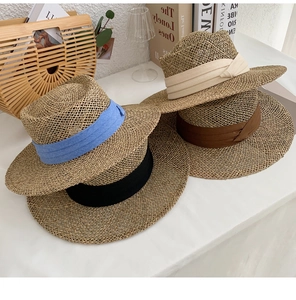 Detailed stack of handmade seagrass sun hats in blue, black, beige, and coffee colors