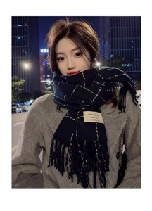 Close-up of deep blue plaid scarf with white lines and soft long tassels texture