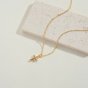 Elegant gold cross necklace featuring vibrant multi-colored zircon stones on stone decor