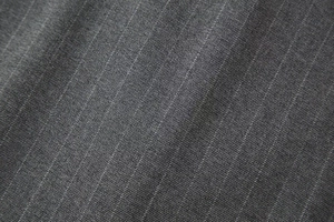 Gros plan sur la texture du tissu denim sergé gris foncé avec tissage visible pour ensemble