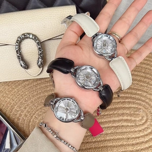 Close-up of elegant women's watch with rhinestone dial and leather strap in three colors