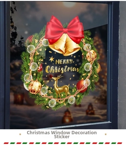 Detail of Christmas wreath window decal featuring red bows and gold bells on glass pane