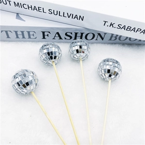 Silver mirror disco ball cake toppers with wooden sticks on a white plush background