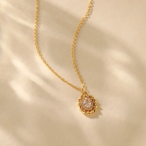Macro shot of 18K gold plated necklace with oval zircon pendant and rope edge