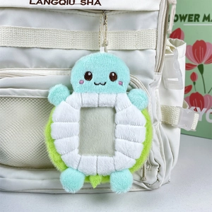 Cute blue plush turtle card holder keychain shown hanging on a white backpack