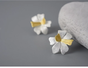 Macro detail of S925 sterling silver petal earrings with brushed two-tone texture