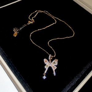 Close-up of golden butterfly pendant necklace with sparkling stones in a velvet box