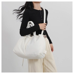 Close-up of white padded nylon tote bag with drawstring closure and soft texture detail