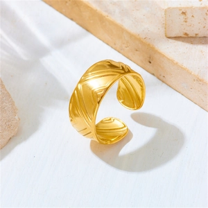 Detailed view of the golden adjustable stainless steel ring with textured leaf pattern