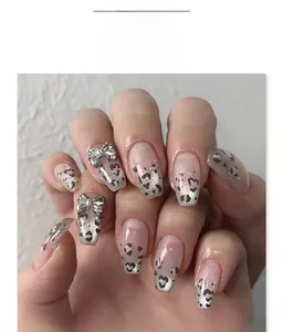 Detail of coffin nails with leopard print, black hearts, and 3D silver bow accents