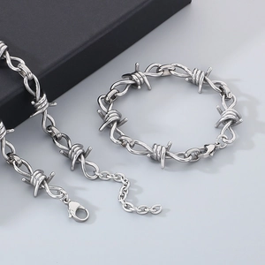 Detailed view of silver thorn-style chain necklace and bracelet set in stainless steel