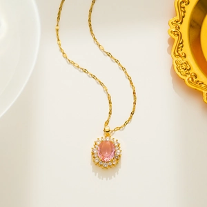 Macro detail of oval pink crystal pendant with halo setting on gold twisted chain