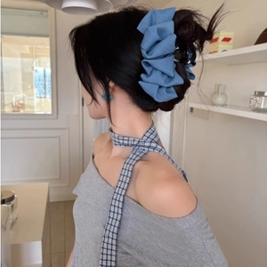 Blue denim bow claw clip in large size for women, shown on a model for hair styling
