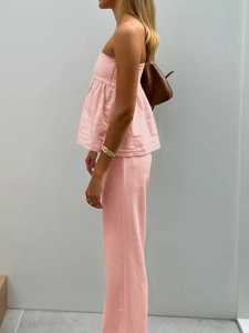 Vue latérale d'un haut bustier rose et d'un pantalon en lin avec sac en cuir
