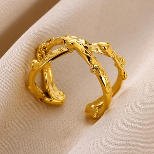 Detailed macro view of the gold irregular lava texture and double cross open ring design
