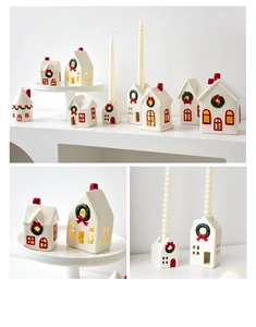Detail of white ceramic Christmas house candle holder with hand-painted festive wreath