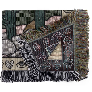 Close-up of bohemian woven blanket with fringe and intricate cactus patterns