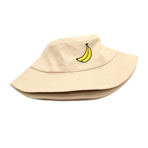 Close-up of yellow banana embroidery on a beige cotton canvas bucket hat fabric