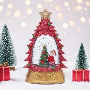 Luminous red Christmas tree crystal ball with snowy scene and warm festive light