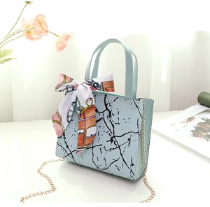 Detail of light blue marble pattern PU handbag with decorative silk scarf and gold chain