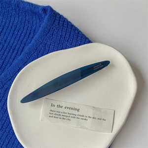 Detail of dark blue acetate hair clip with FRANCE Handmade text on ceramic tray