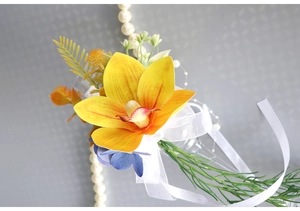 Detailed view of yellow cymbidium wine glass flower with blue petals and white organza ribbon