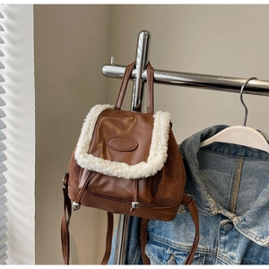 Détail du sac à dos seau marron rétro avec bordure en fausse fourrure blanche et logo