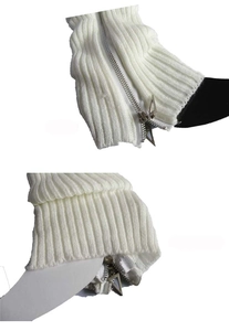 Close-up of white ribbed knit leg warmers with metallic side zipper and pull detail