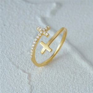 Macro detail of gold double-layered cross ring with zircon accents and adjustable open band