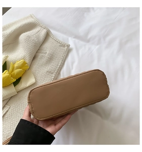 Detailed bottom view of khaki leather shell bag showing neat stitching and structured base