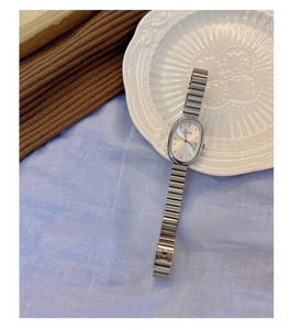 Detailed view of vintage oval silver watch on elegant relief porcelain plate decoration