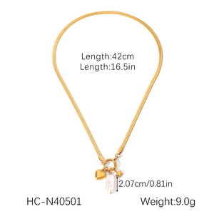 Flat lay of gold snake chain necklace featuring heart, star and baroque pearl pendants