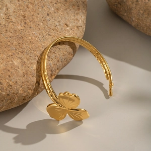 Détail du bracelet jonc ouvert plaqué or 18K avec texture martelée et motif trèfle