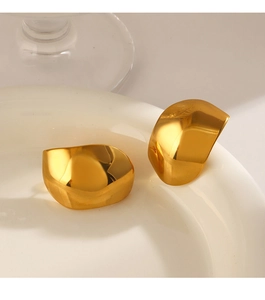 Macro shot of 18k gold plated irregular geometric earrings on a white ceramic plate