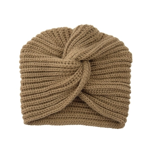 Detailed close-up of a camel knitted turban hat featuring a stylish cross knot design