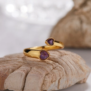 Detail of S925 silver 18K gold ring featuring heart-shaped purple garnets on natural rock