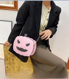 Pink pumpkin-shaped crossbody bag with black chain strap worn with a black blazer