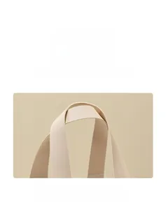 Dettaglio del manico in tessuto beige su una borsa regalo in PVC di lusso dallo stile sobrio