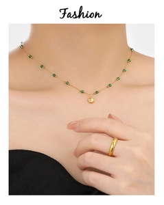 Detail of vintage emerald shell pendant necklace on female model neck in gold finish