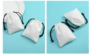 Close-up of white cotton canvas jewelry pouch with black drawstring on blue background